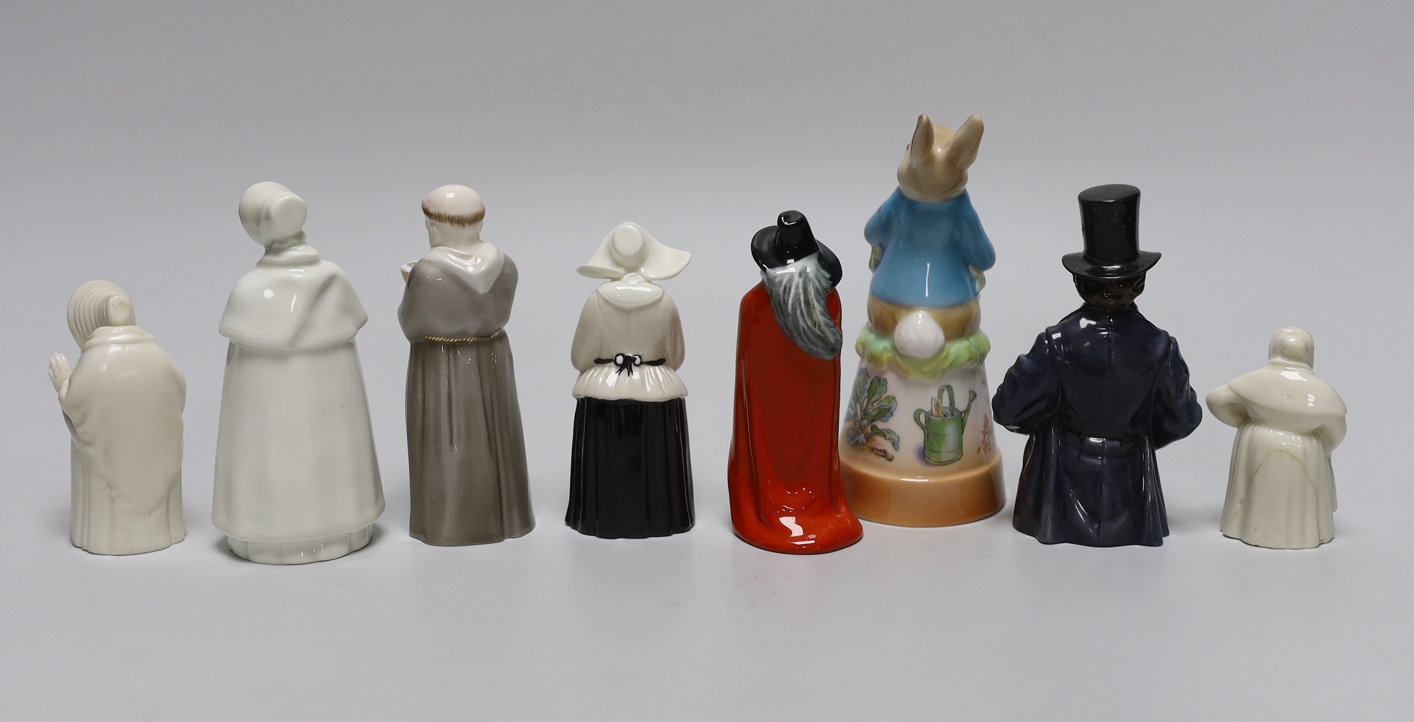 A collection of eight extinguishers including Worcester and Royal Doulton, the largest 13cm high